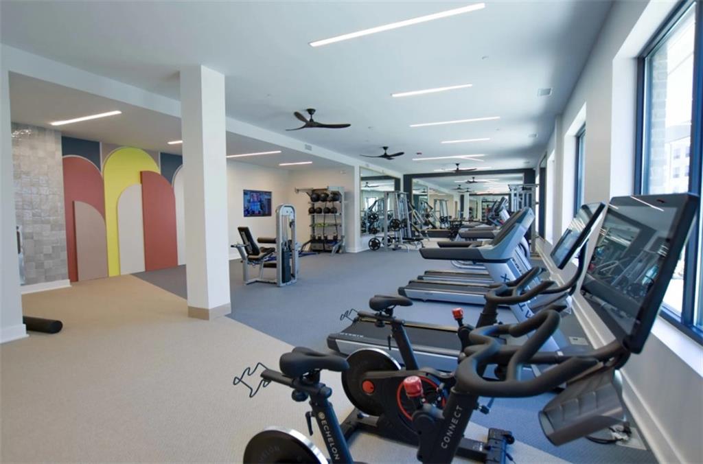 4255 Suwanee Buford Dam Road, Unit 5005202 Suwanee, GA 30024 - Photo 17 of 22 a gym room with lots of gym equipment