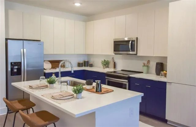 a kitchen with stainless steel appliances kitchen island granite countertop a sink a microwave cabinets and a refrigerator