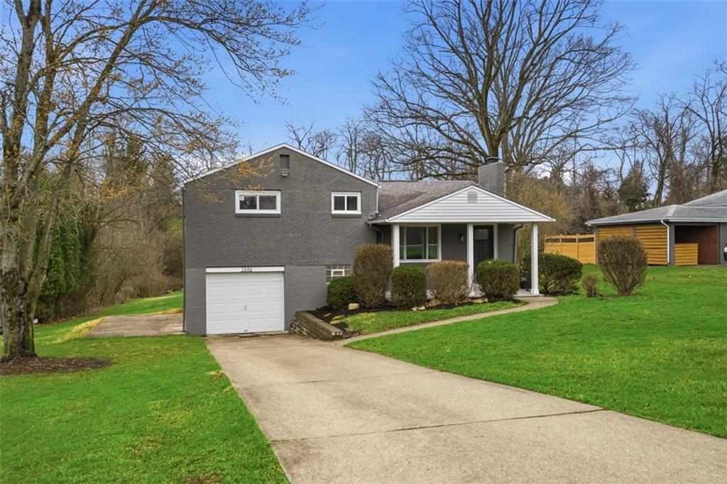 a front view of a house with a yard and trees