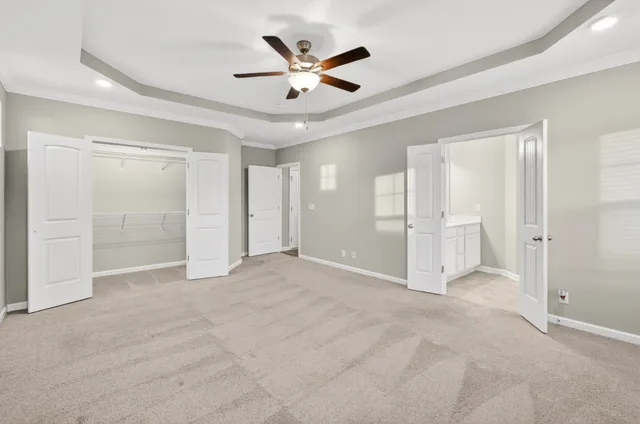 an empty room that has a large window and a ceiling fan