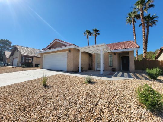 218 Kennedy Court Ridgecrest, CA 93555 - Photo 1 of 19 a front view of a house with a yard and garage