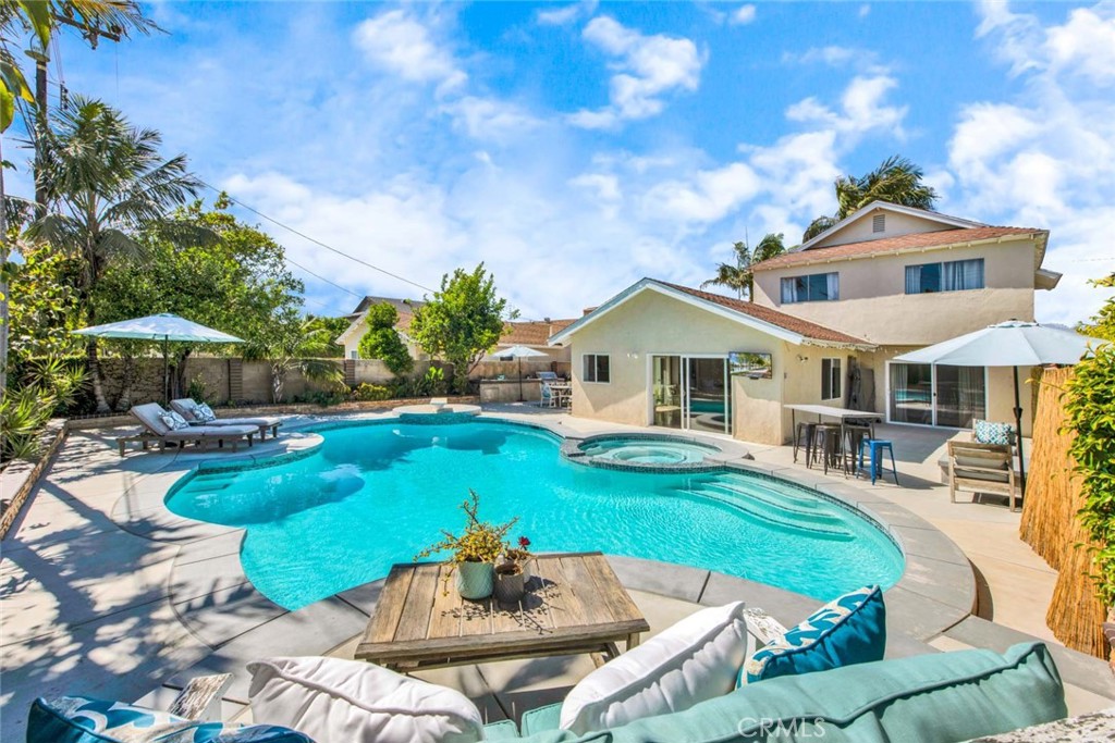 Paradise Found! Amazing Entertainers backyard with sparkling pool, spa, raised fire ring, built-in BBQ center, multiple patio areas, wrap-around upgraded deck, tropical landscaping, fruit trees.