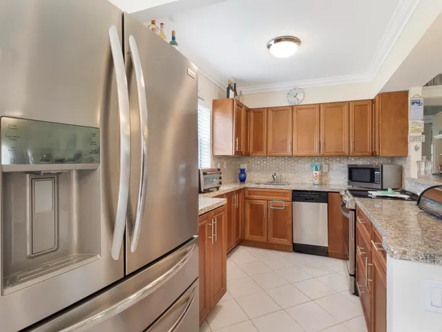 a kitchen with stainless steel appliances granite countertop a refrigerator and a stove top oven