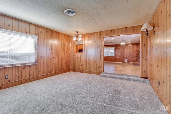 an empty room with a cabinet and mirrors