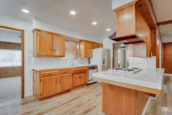 a kitchen with stainless steel appliances granite countertop a sink a stove and a wooden floors