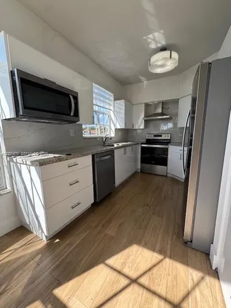 a kitchen with stainless steel appliances kitchen island granite countertop a stove a sink and a microwave