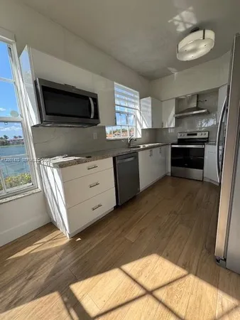 a kitchen with stainless steel appliances kitchen island granite countertop a stove a sink and a microwave
