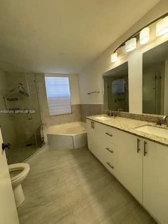a bathroom with a double vanity sink toilet and shower