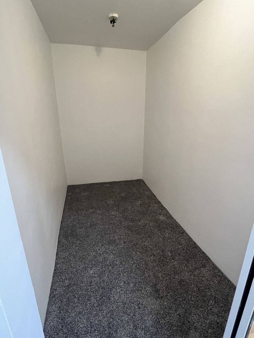 8016 South Halsted Street, Unit 2N Chicago, IL 60620 - Photo 7 of 13 an empty room with a bench