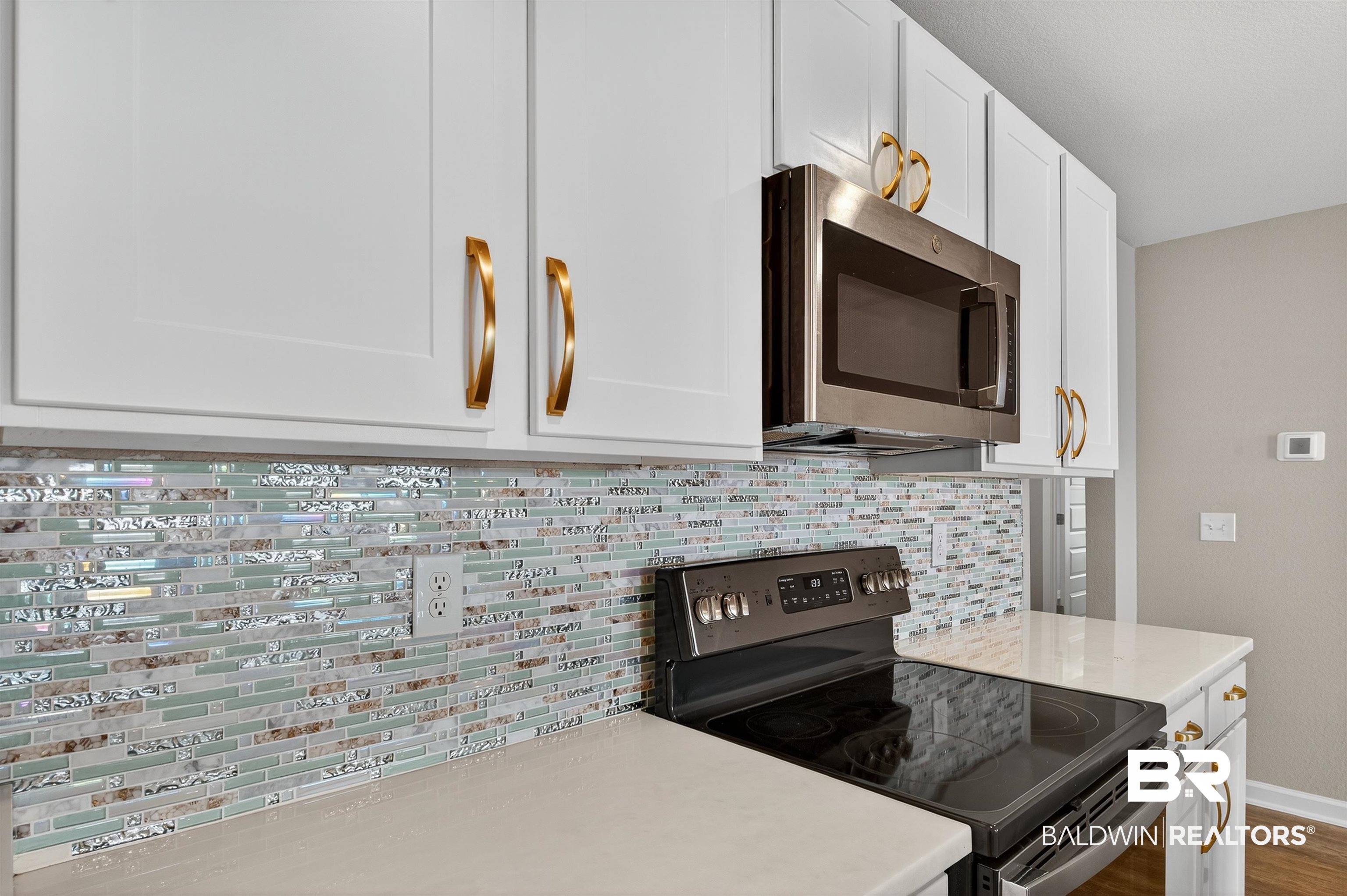 7429 Brompton Drive Foley, AL 36535 - Photo 6 of 50 Kitchen with stainless steel appliances, tasteful backsplash, white cabinetry, wood finished floors, and light stone countertops