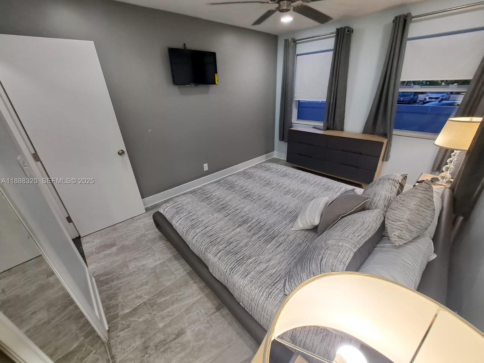 2242 Polk Street, Unit 1 Hollywood, FL 33020 - Photo 12 of 31 a bedroom with a bed and a flat screen tv