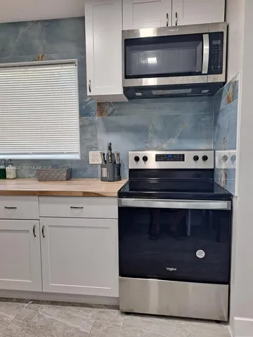 a stove top oven sitting inside of a kitchen