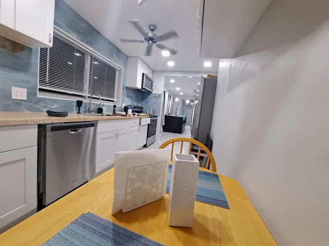 a kitchen with kitchen island a white counter top space cabinets and stainless steel appliances