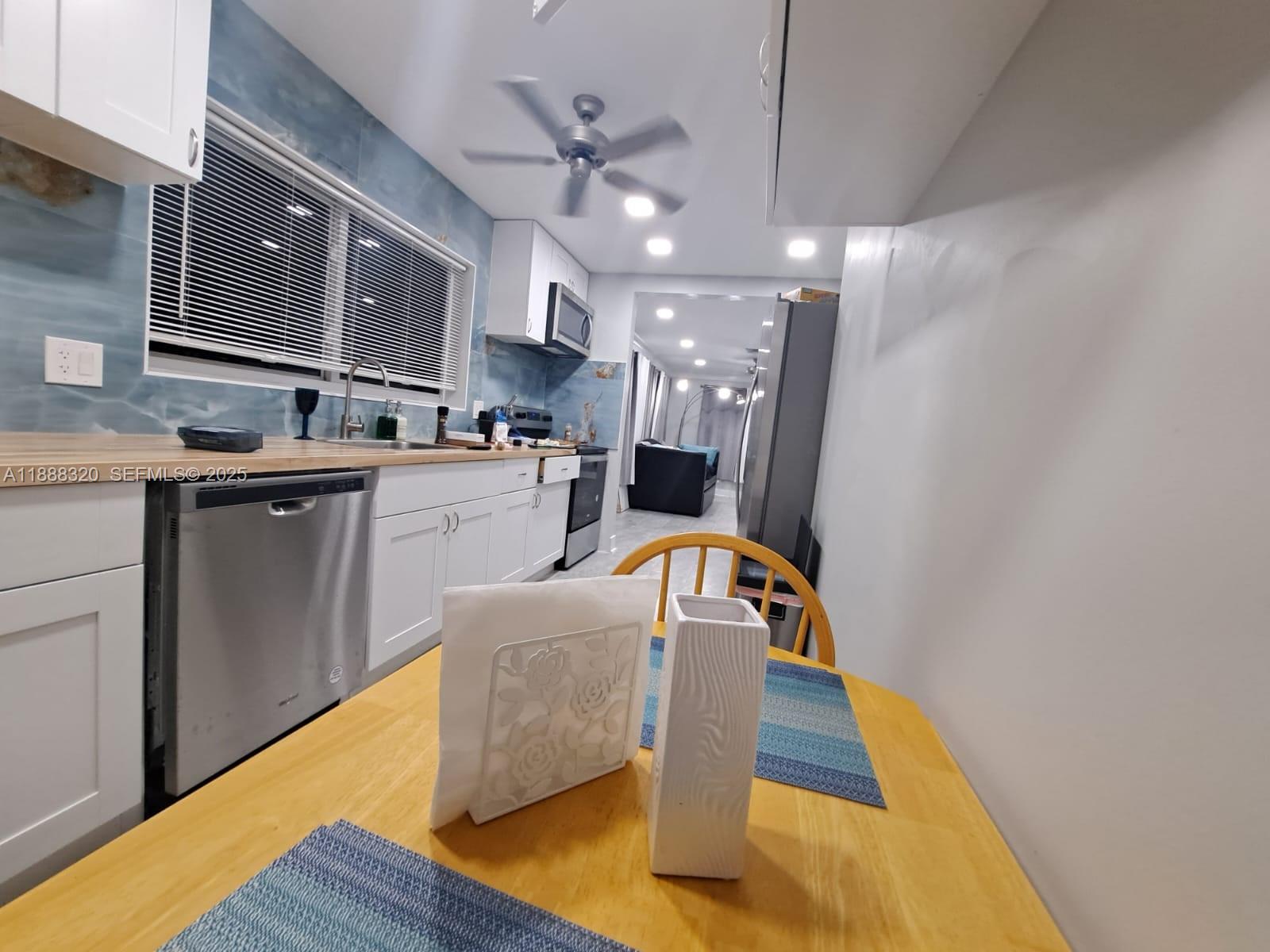 2242 Polk Street, Unit 1 Hollywood, FL 33020 - Photo 20 of 31 a kitchen with kitchen island a white counter top space cabinets and stainless steel appliances