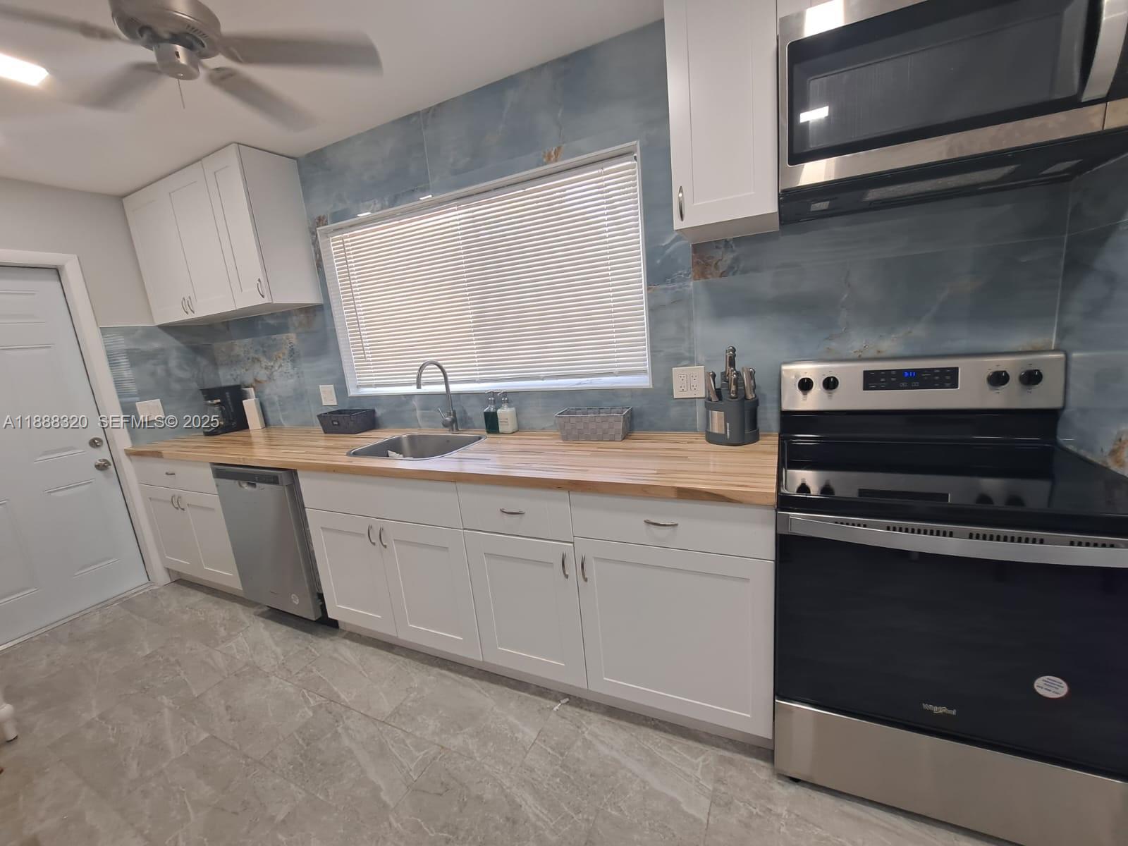 2242 Polk Street, Unit 1 Hollywood, FL 33020 - Photo 21 of 31 a kitchen that has a sink and a stove