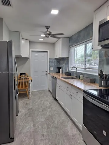 a kitchen with stainless steel appliances a sink stove and refrigerator