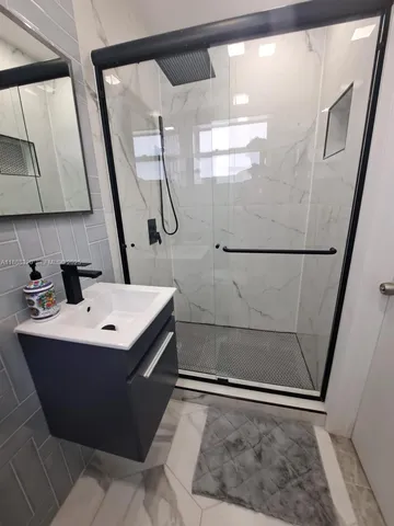 a bathroom with a sink a mirror and a shower