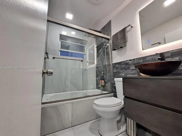 a bathroom with a toilet sink and shower