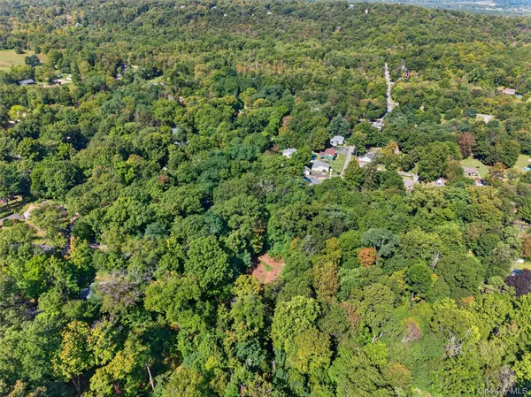 an aerial view of residential house with outdoor space and trees all around