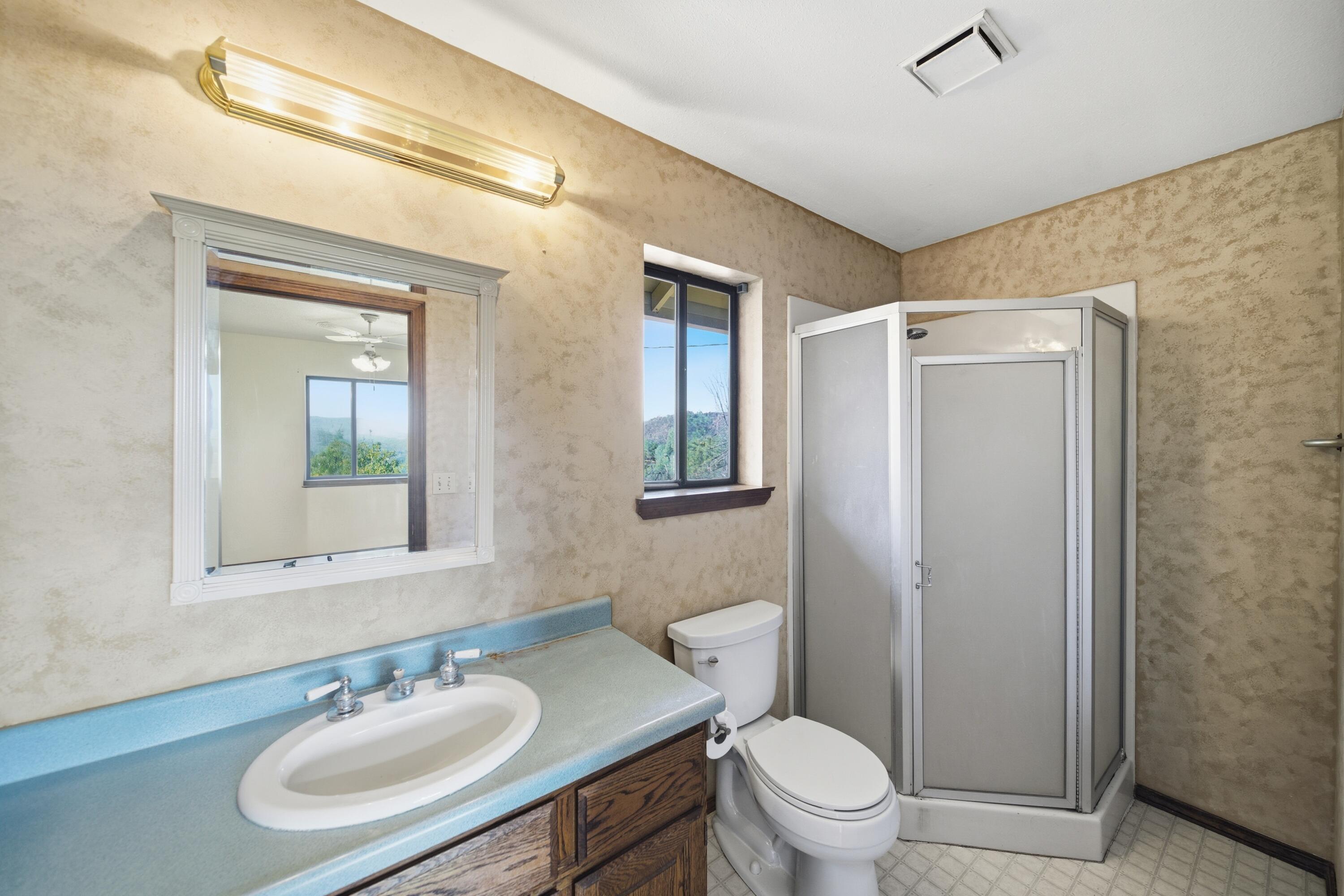 14018 Highview Trail Redding, CA 96003 - Photo 21 of 41 a bathroom with a sink toilet a mirror and shower