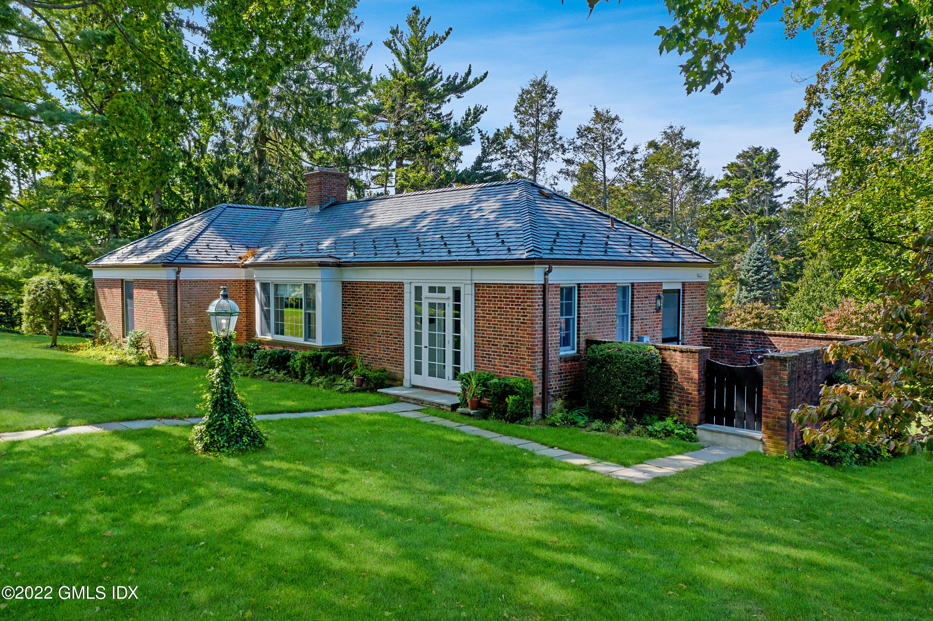 a front view of a house with a yard and green space