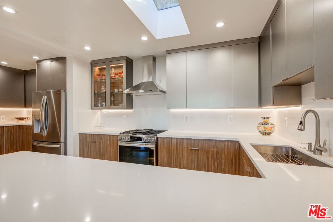 4520 Gable Drive Encino, CA 91316 - Photo 39 of 58 a kitchen with kitchen island a counter space a sink and stainless steel appliances