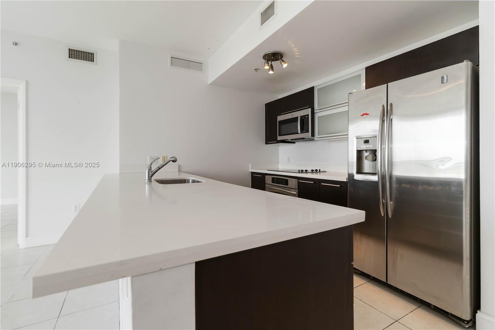 90 Southwest 3rd Street, Unit 4305 Miami, FL 33130 - Photo 5 of 16 a kitchen with stainless steel appliances a refrigerator and a sink