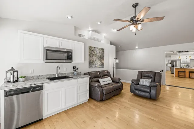 a living room with furniture kitchen view and a flat screen tv