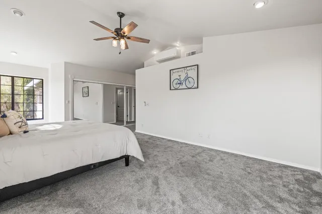 a bed room with a bed and a ceiling fan