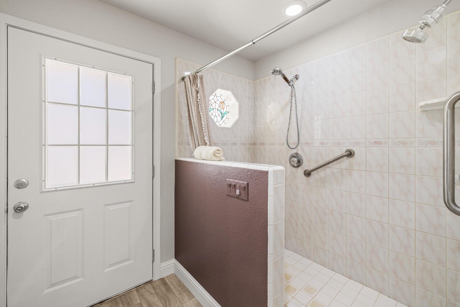 14580 McElroy Road Auburn, CA 95602 - Photo 19 of 48 a bathroom with a shower a mirror and a window