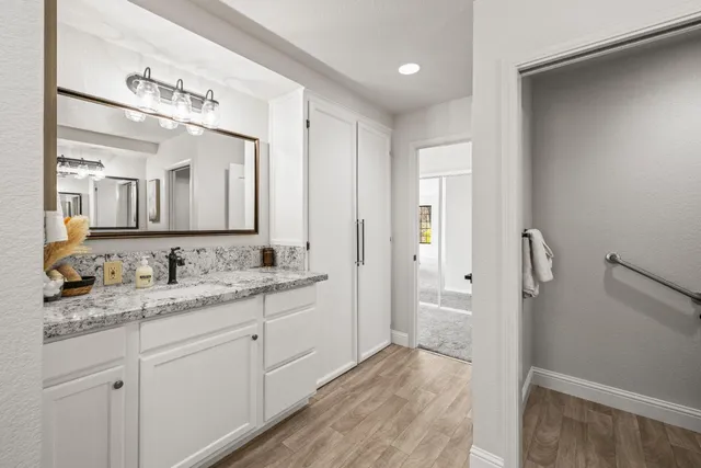a bathroom with a granite countertop sink and a mirror