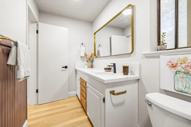 a bathroom with a sink a toilet and a mirror