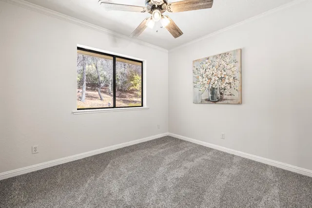 an empty room with a window and a fan