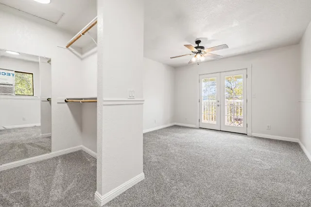 an empty room with windows and cabinet