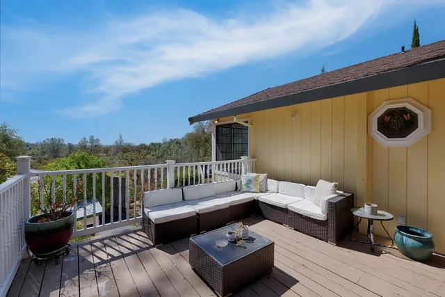 a balcony with wooden floor and furniture