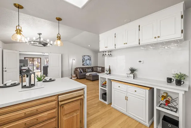 a kitchen with kitchen island granite countertop a sink a stove and cabinets