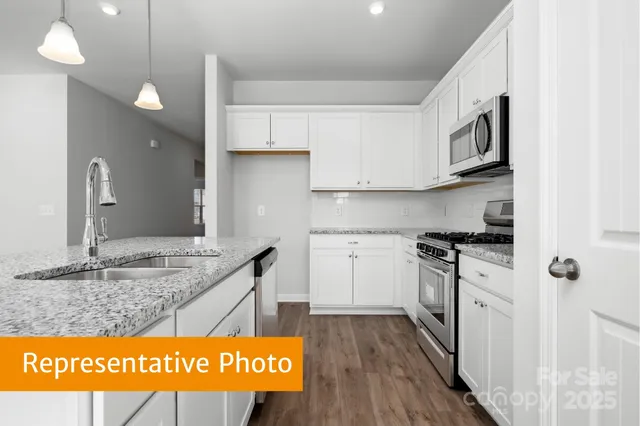 a kitchen with stainless steel appliances granite countertop a stove a sink and a refrigerator