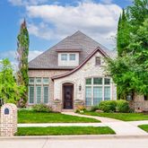 a front view of a house with a yard and trees