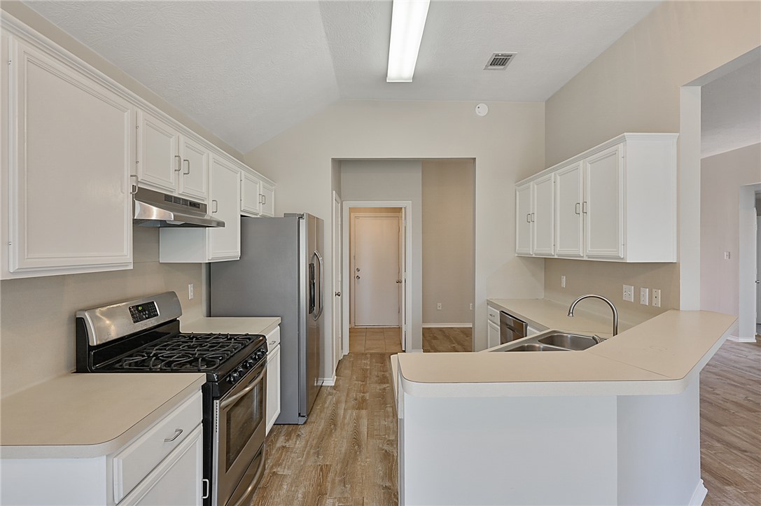 1804 Ibis Court Bryan, TX 77807 - Photo 4 of 17 a kitchen with stainless steel appliances granite countertop a sink stove and refrigerator