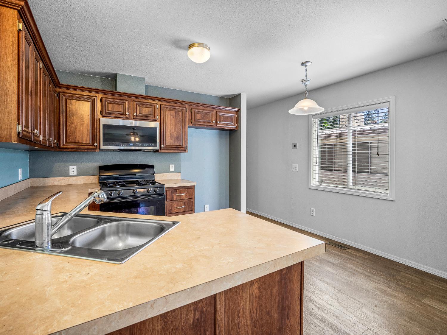 2933 Forebay Road, Unit 28 Pollock Pines, CA 95726 - Photo 16 of 26 a kitchen with stainless steel appliances a stove a sink a microwave a refrigerator and cabinets