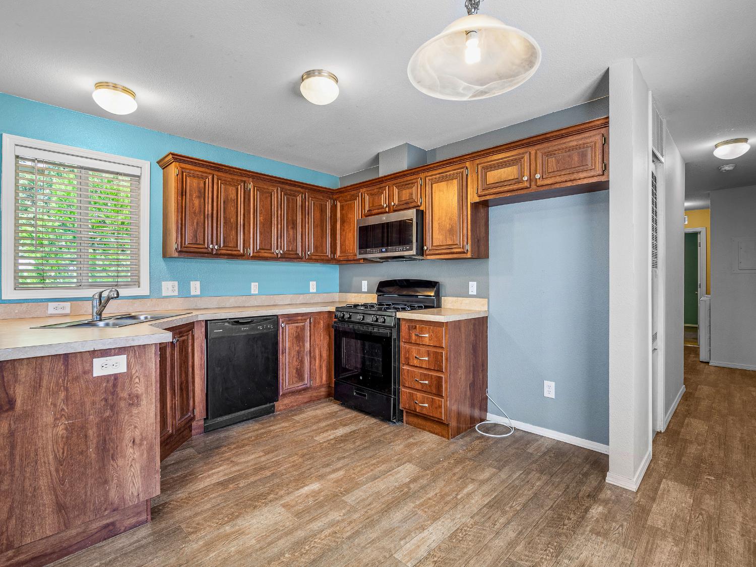 2933 Forebay Road, Unit 28 Pollock Pines, CA 95726 - Photo 18 of 26 a kitchen with granite countertop a stove top oven a sink dishwasher and a refrigerator with wooden floor