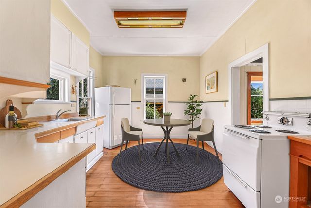 a living room with stainless steel appliances furniture a couch and a kitchen view