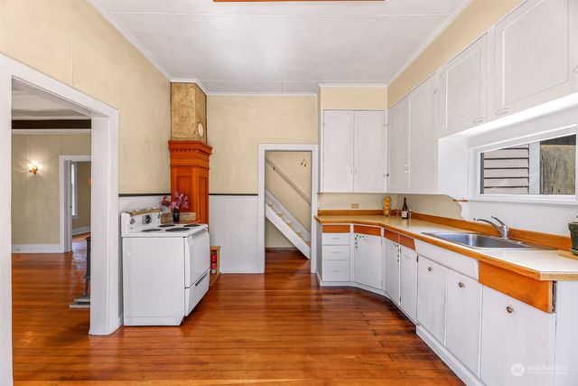 a kitchen with sink cabinets and wooden floor