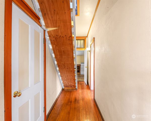a view of a hallway with wooden floor and staircase