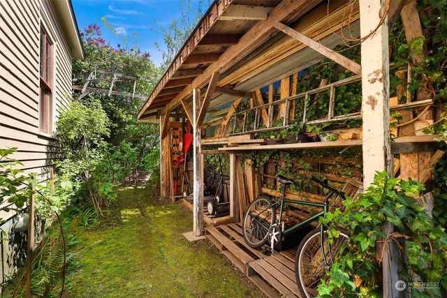 a view of a house with a large window and potted plants