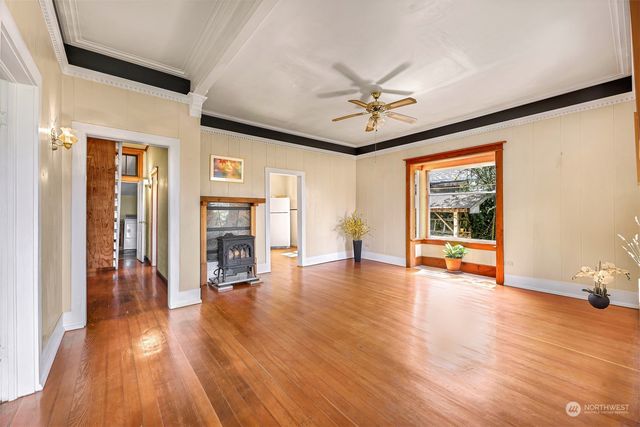 a view of a livingroom with wooden floor and a ceiling fan