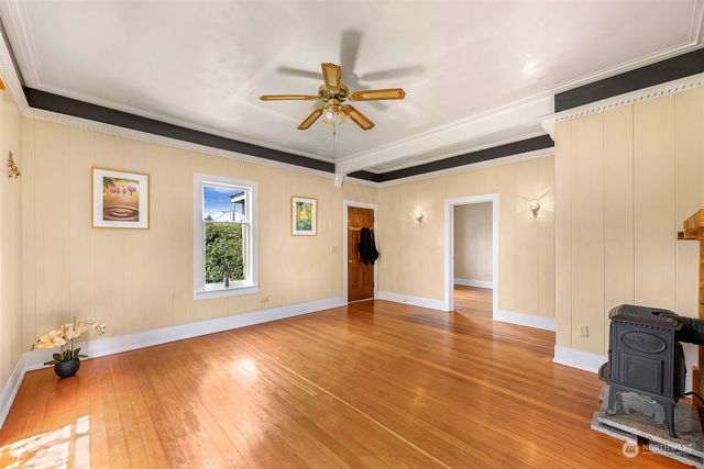a view of an empty room with window and wooden floor