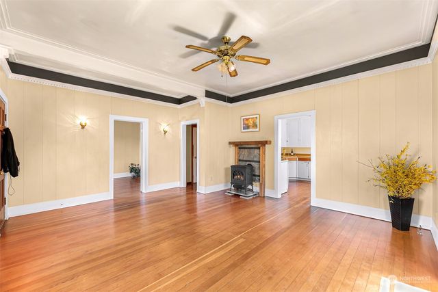a view of an empty room with a window and wooden floor