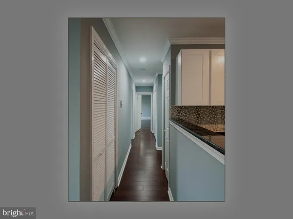 a view of a hallway to a livingroom and a kitchen with a sink