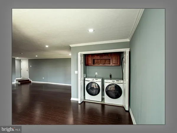 a view of a hallway with wooden floor and a window